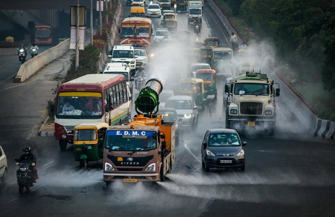 Archivo - Camiones refrescan las calles en India para reducir la contaminación.