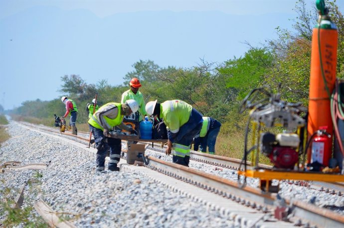 Operarios de Comsa Corporación instalan vías de ferrocarril.