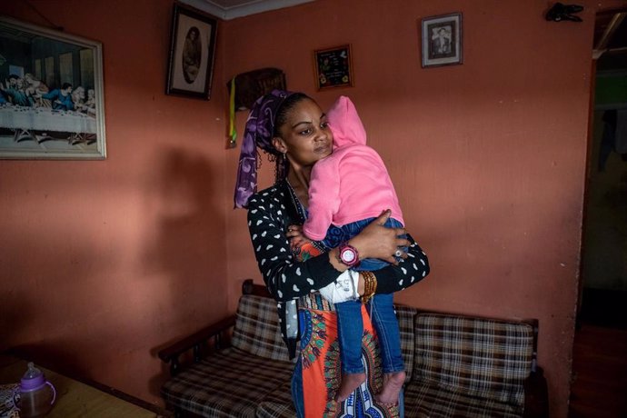 Archivo - Una mujer sudafricana con su bebé en brazos.