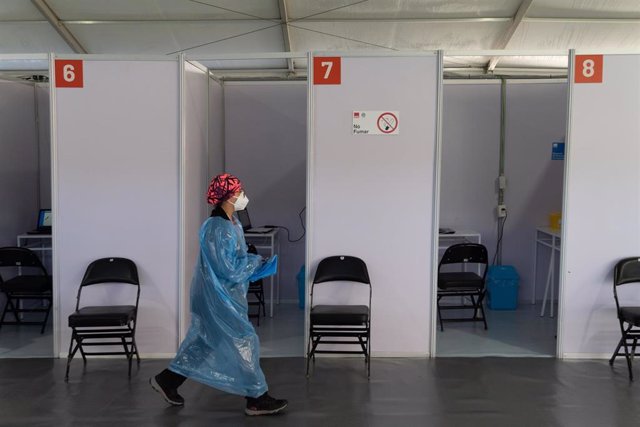 Archivo - Una trabajadora de la salud pasa por delante de los puestos instalados en un centro de vacunación en el Estadio Bicentenario