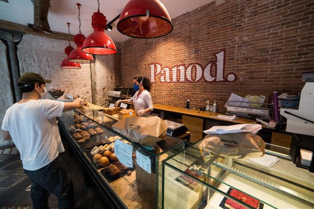 Archivo - Una trabajadora de la panadería Panod atiende a un cliente, en Madrid (España).