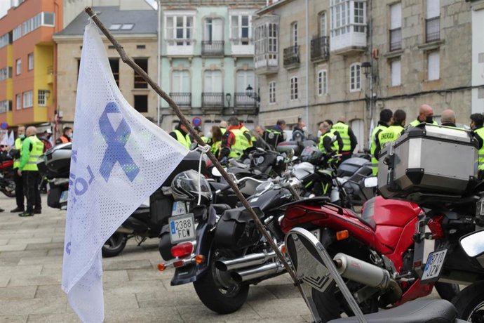 Tres personas posan junto a una bandera donde se lee "A Mariña se salva luchando", antes del inicio de una caravana motera por el futuro de la planta de Alcoa en San Cibrao, a 21 de noviembre de 2021, en Ferreira de Valadouro, Lugo, Galicia (España). Tr