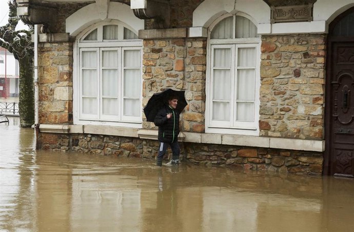 Un hombre camina por una vía inundada debido a las fuertes lluvias registradas, a 29 de noviembre de 2021, en Ampuero, Cantabria, (España). 