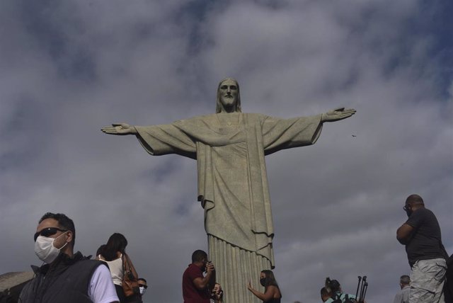 Archivo - Personas con mascarilla por el coronavirus junto al Cristo del Corcovado de Río de Janeiro
