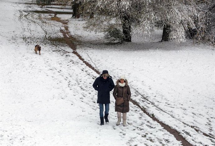 Dos personas caminan sobre la nieve, a 28 de noviembre de 2021, en Burgos, Castilla y León (España). Un total de 31 provincias se encuentran bajo diferentes niveles de riesgo por nieve, lluvia, viento, fuerte oleaje, deshielo y temperaturas mínimas, seg