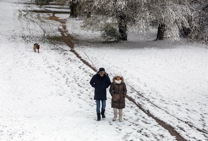 Dos personas caminan sobre la nieve, a 28 de noviembre de 2021, en Burgos, Castilla y León (España). Un total de 31 provincias se encuentran bajo diferentes niveles de riesgo por nieve, lluvia, viento, fuerte oleaje, deshielo y temperaturas mínimas, seg