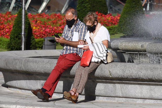 Imagen de ciudadanos en Bilbao, uno de ellos usando su móvil.