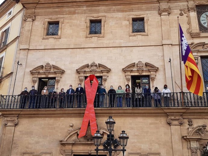 El lazo rojo símbolo de la lucha contra el SIDA luce en la fachada de Cort.