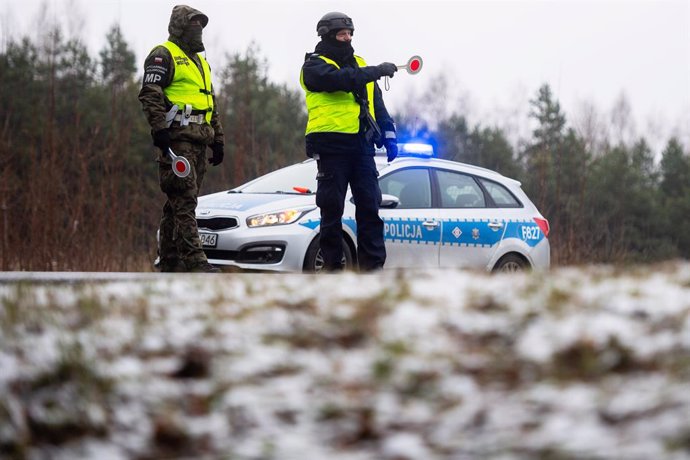 24 November 2021, Poland, Kuznica: A Polish soldier and a police officer work at a checkpoint for vehicles entering the state of the emergency area near the town of Kuznica on the Polish-Belarusian border. On Thursday, the Polish border guard said there