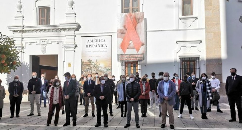 Foto de familia frente a un lazo rojo colocado en la fachada de la Asamblea con motivo del Día Mundial del Sida