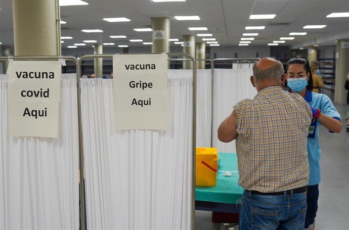 Archivo - Una `persona se vacuna con la tercera dosis Covid y la vacuna de la gripe a 18 de octubre del 2021 en Sevilla (Andalucía). La Consejería de Salud y Familias de la Junta de Andalucía ha comenzado este lunes, la administración de la tercera dosi