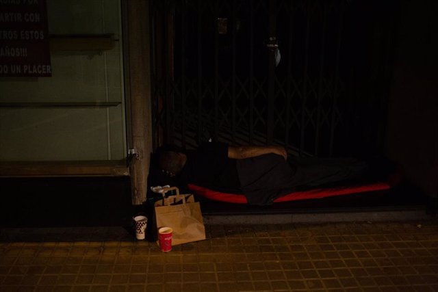 Archivo - Un hombre duerme en un portal en la calle 