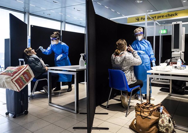 30 November 2021, Netherlands, Amsterdam: Medics test travellers from South Africa for coronavirus infections upon arrival at Schiphol Airport after the Omikron COVID-19 variant was detected. Photo: Remko De Waal/ANP/dpa