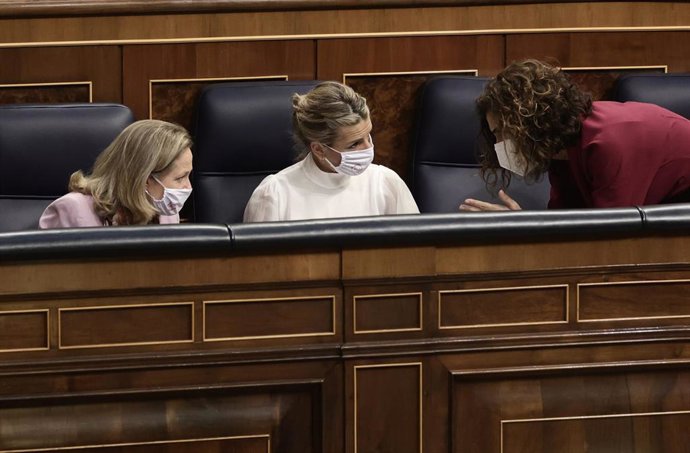 (I-D) La vicepresidenta primera del Gobierno, Nadia Calviño; la vicepresidenta segunda del Gobierno y ministra de Trabajo, Yolanda Díaz; y la ministra de Hacienda, María Jesús Montero, conversan en una sesión plenaria en el Congreso 