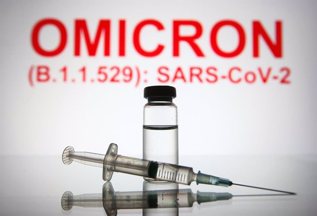 26 November 2021, Ukraine, ---: An illustration photo shows a medical syringe and a vial in front of the text Omicron (B.1.1.529): SARS-CoV-2 in the background. The mutated strain, called "Omicron" and described by the World Health Organization as "a stra