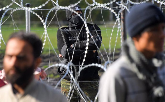 Archivo - 6662936 29.09.2021 A Polish border guard watches a refugee camp behind barbed wire installed on the border between Belarus and Poland near the village of Usnarz Dolny, Belarus. In recent months, Latvia, Lithuania and Poland have reported an in