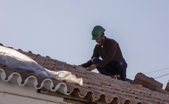 Un obrero realiza su labor en el tejado de una vivienda, en foto de archivo.