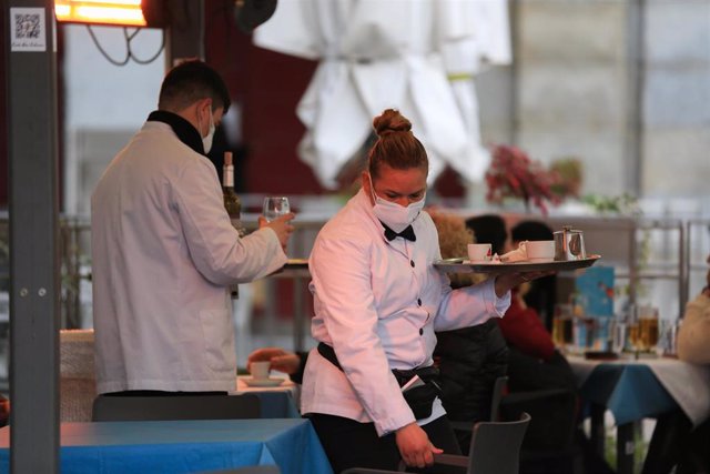 Archivo - Dos camareros trabajan en la terraza de un bar en el centro de Madrid (España), a 5 de febrero de 2021. La Comunidad de Madrid amplía desde este viernes el número de personas que pueden compartir mesa en las terrazas, que pasa de cuatro a un máx