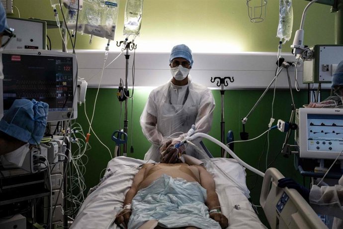 Archivo - FILED - 08 September 2021, France, Pierre-Benite: A medical employee stands behind a patient infected with coronavirus in the intensive care unit of the Lyon-South hospital. Photo: Jeff Pachoud/AFP/dpa