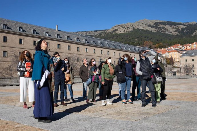 Una actriz de la asociación Deverde (2i) interpreta a la esposa de Felipe II, María Manuela de Portugal, como guía para un grupo de turistas en una vía de San Lorenzo de El Escorial, en San Lorenzo de El Escorial, Madrid, (España). 