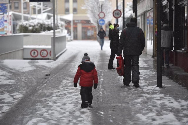Archivo - Gente paseando con nieve por Huesca.