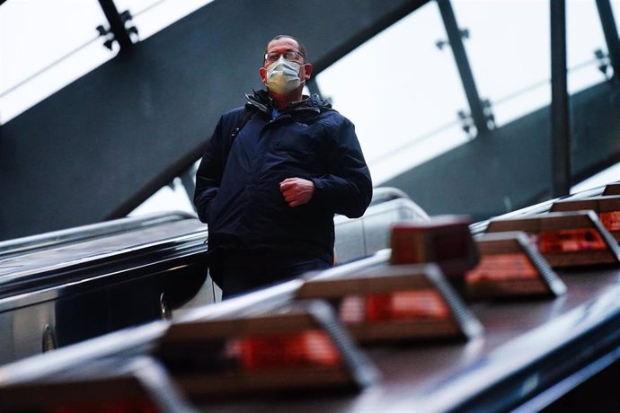 30 November 2021, United Kingdom, London: A commuter in Canary Wharf underground tube station wears a face covering as mask wearing on public transport becomes mandatory to contain the spread of the Omicron Covid-19 variant. Photo: Victoria Jones/PA Wir