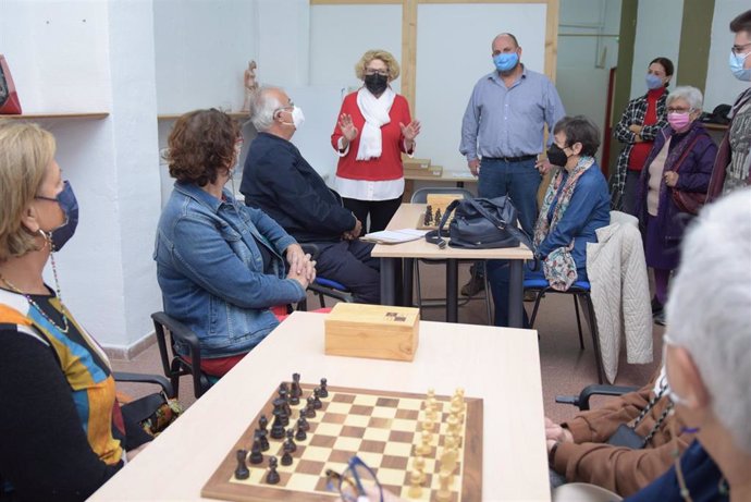 Imagen adjunta del vicerrector y la concejala saludando a los usuarios y el monitor del taller de ajedrez.