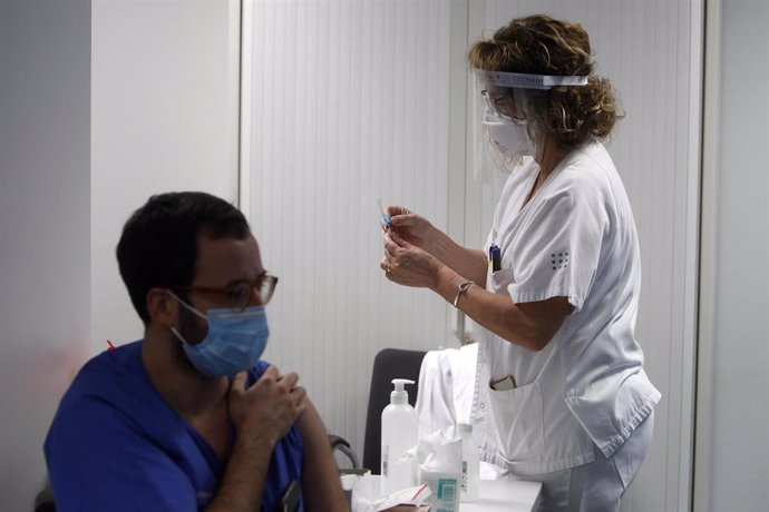 Archivo - Una enfermera prepara la vacuna Pfizer-BioNtech contra el COVID-19 antes de administrársela a un profesional sanitario en el Hospital Son Espases de Palma.