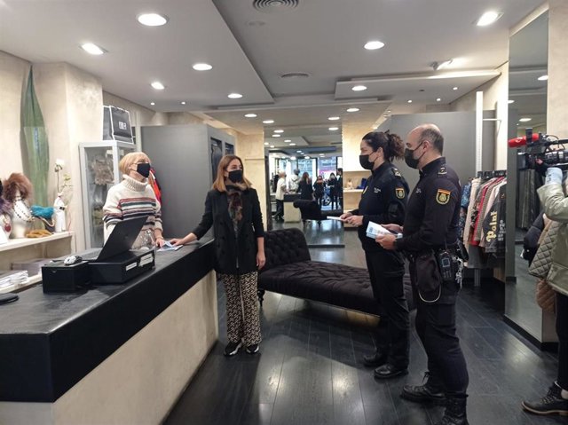 Agentes de la Policía Nacional entregan una guía con consejos a dependientas de una tienda de Logroño