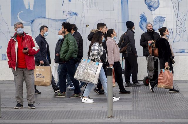 Varias personas caminan con bolsas con compras, a 25 de noviembre de 2021, en Madrid (España). El Black Friday se celebra después del día de Acción de Gracias y se caracteriza por que en él se lanzan ofertas en los comercios de cara a las compras navideña