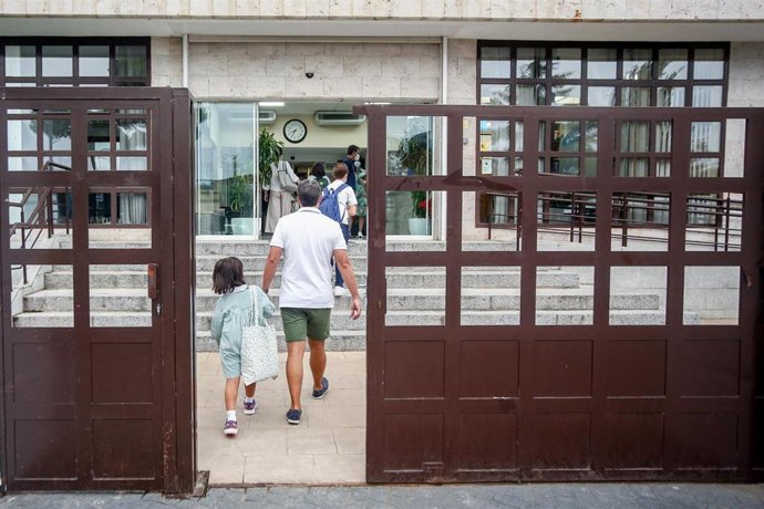 Archivo - Un padre acompaña a su hijo a la entrada del colegio. 