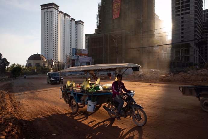 Archivo - Un hombre con su motocicleta en Camboya.