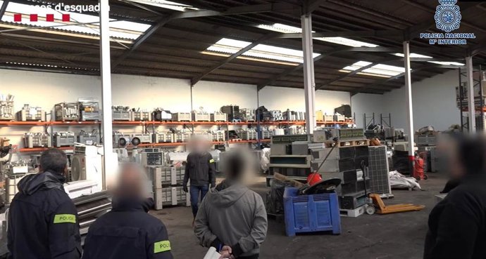 Agentes de los Mossos d'Esquadra y la Policía Nacional durante la entrada y el registro de la nave donde los presuntos responsables guardaban material incautado en intervenciones policiales para venderlo en Tarragona