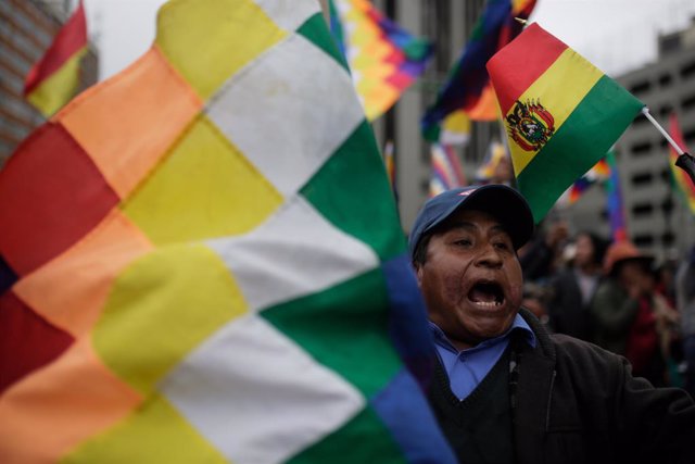 Archivo - 12 November 2019, Bolivia, La Paz: A Supporter of Bolivian former President Evo Morales, shout slogans and holds the "wiphala" flag that represent the nation's indigenous people, takes part in a protest. Photo: Gaston Brito/dpa