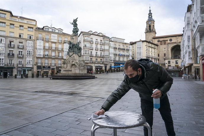 Archivo - Un camarero limpia una mesa de la terraza de su cafetería durante una jornada marcada por la reapertura de los establecimientos en los municipios vascos pertenecientes a la zona roja, en Vitoria, Álava, País Vasco, (España), a 10 de febrero 