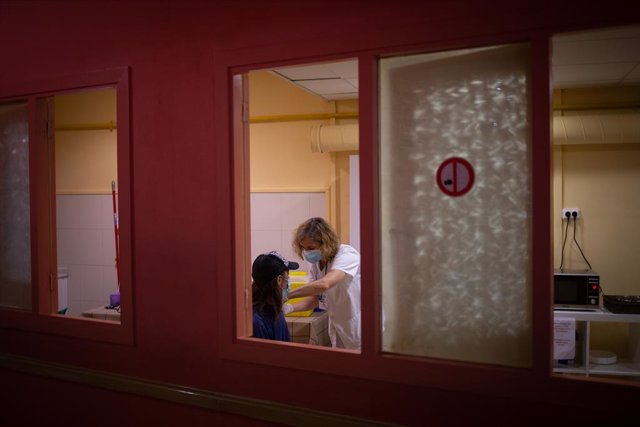 Archivo - Arxivo - Una sanitària vacuna a una dona sense llar, en la jornada de vacunació a persones sense llar al centre obert de la Fundació Arrels.