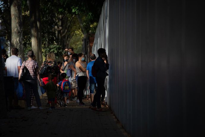 Archivo - Arxivo - Pares i alumnes esperen les portes d'un collegi a Barcelona.