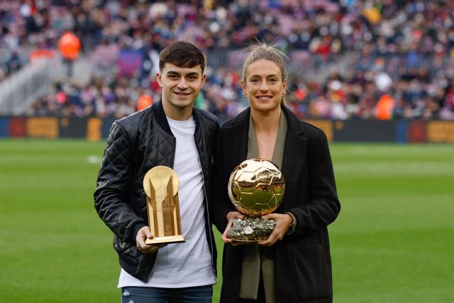 Pedri and Alexia Putellas of FC Barcelona poses for photo with golden boy and women ballon d’or trophy during the La Liga match between FC Barcelona and Betis at Camp Nou Stadium on December 04, 2021 in Barcelona.