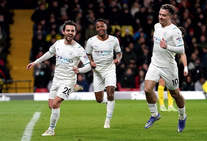 04 December 2021, United Kingdom, Watford: (L-R) Manchester City's Bernardo Silva celebrates scoring his side's third goal with teammates Raheem Sterling and Jack Grealish during the English Premier League soccer match between Watford and Manchester Cit