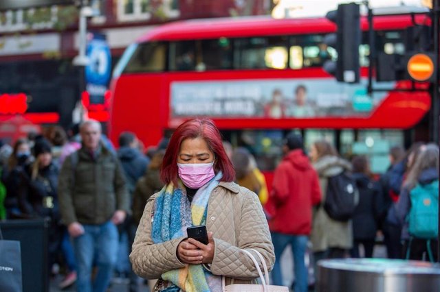 Una mujer con mascarilla pasea por Londres