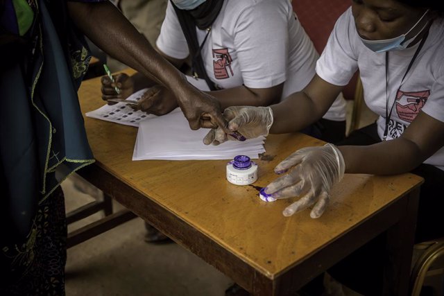 04 December 2021, Gambia, Banjul: An official dips a voter's finger in ink to ensure they do not vote twice during the presidential elections. Photo: Sally Hayden/SOPA Images via ZUMA Press Wire/dpa