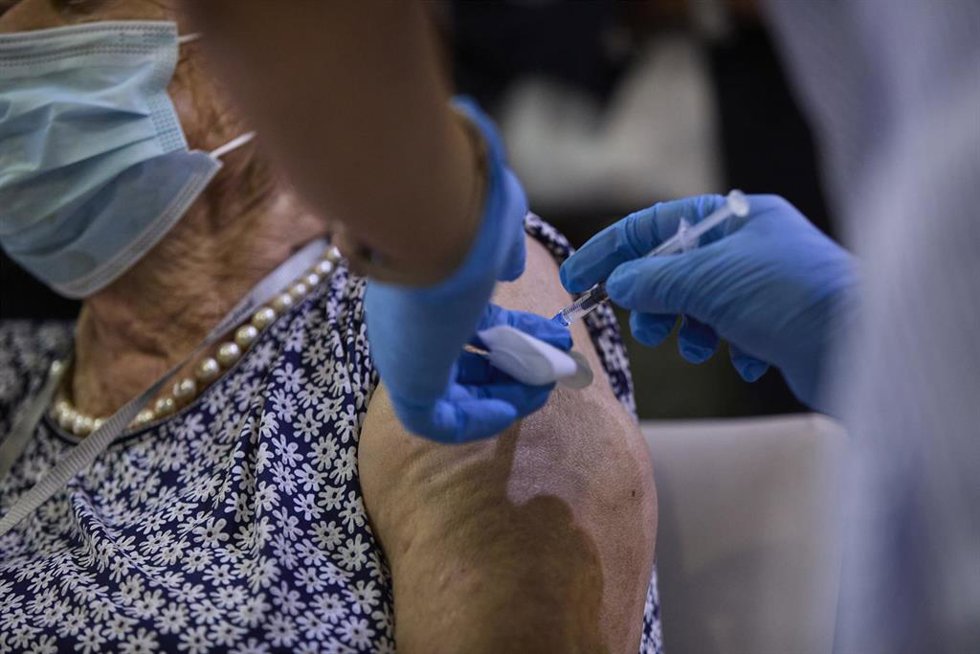 Archivo - Una sanitaria vacuna a una mujer con la tercera dosis del Covid-19.