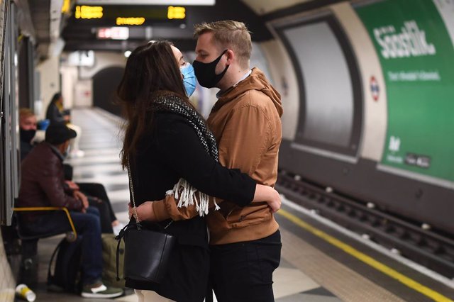 Archivo - Una pareja con mascarillas en el metro de Londres