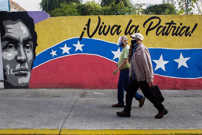 Dos personas pasean frente a un mural durante la jornada electoral de noviembre
