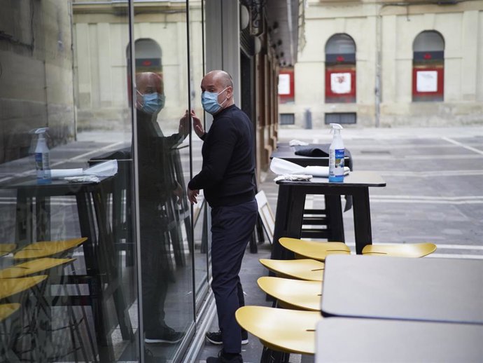 Archivo - Un hombre prepara la terraza de un bar de Pamplona durante el primer día de la desescalada de la segunda ola del coronavirus en Navarra (España), a 26 de noviembre de 2020. 