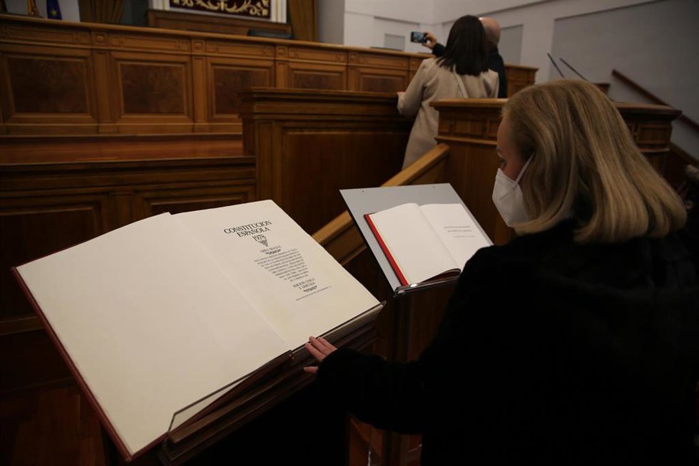 Una mujer observa un ejemplar de la Constitución Española, en el salón de plenos de las Cortes de Castilla-La Mancha, a 4 de diciembre de 2021, en Toledo, Castilla-La Mancha (España). 
