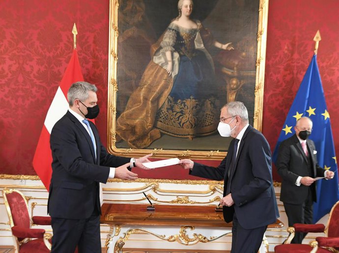 06 December 2021, Austria, Vienna: Austrian President Alexander Van der Bellen hands Karl Nehammer his certificate of appointment as Chancellor, during the swearing-in ceremony of the new OeVP government members at the Presidential palace in Vienna. Pho