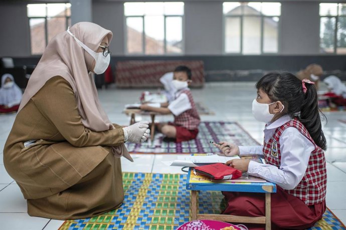 Archivo - Una estudiante de 7 años con su maestra durante una clase en el salón de la aldea local en Bandung, provincia de Java Occidental, Indonesia