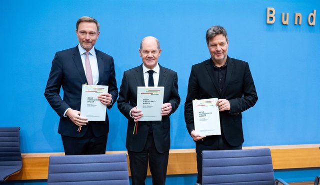 07 December 2021, Berlin: (l-R) Christian Lindner, designated German Minister of Finance, Olaf Scholz, designated German Chancellor, Robert Habeck, designated German Minister of Economics and Climate Protection, hold the coalition agreement at the Federal