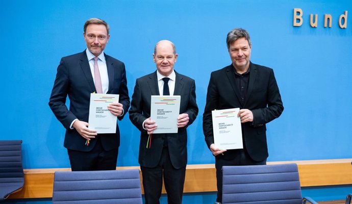 07 December 2021, Berlin: (l-R) Christian Lindner, designated German Minister of Finance, Olaf Scholz, designated German Chancellor, Robert Habeck, designated German Minister of Economics and Climate Protection, hold the coalition agreement at the Feder